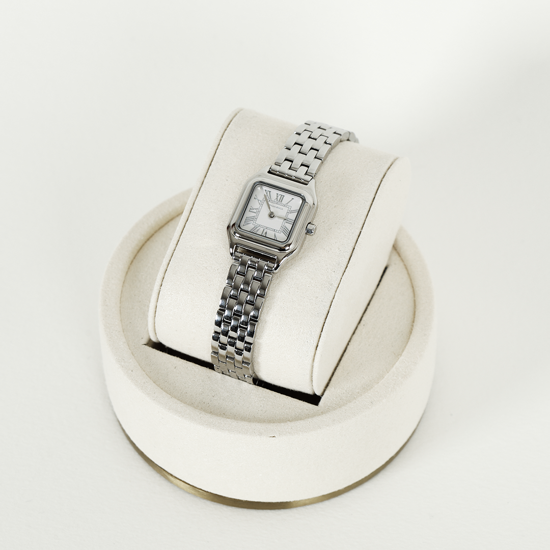 A silver-toned Louis Watch with a link bracelet and a square face featuring Roman numerals.