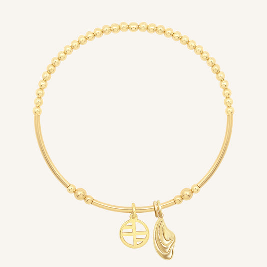 Gold bracelet with two charms on a white background