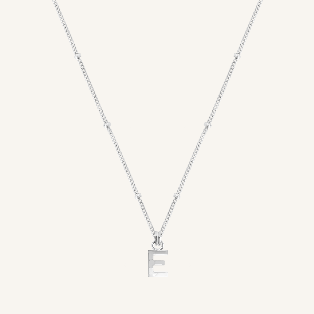 Silver necklace with a letter 'E' pendant on a light gray background