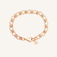 A gold-colored bracelet featuring a chain design and a decorative element shaped like the Eiffel Tower.
