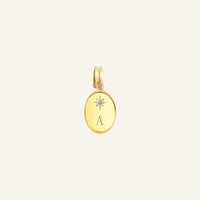 Gold pendant with 'A' initial on a light beige background