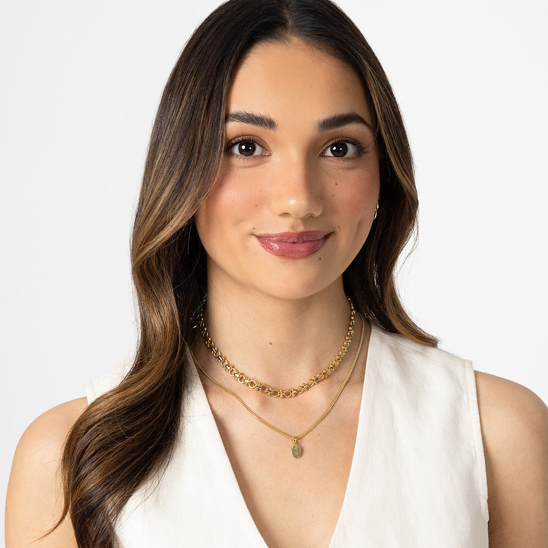 Woman wearing gold necklaces on a white background