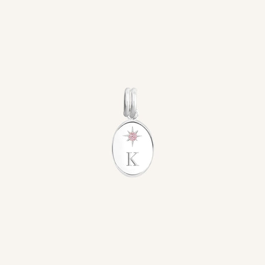 Silver pendant with a letter 'K' on an oval plate against a white background