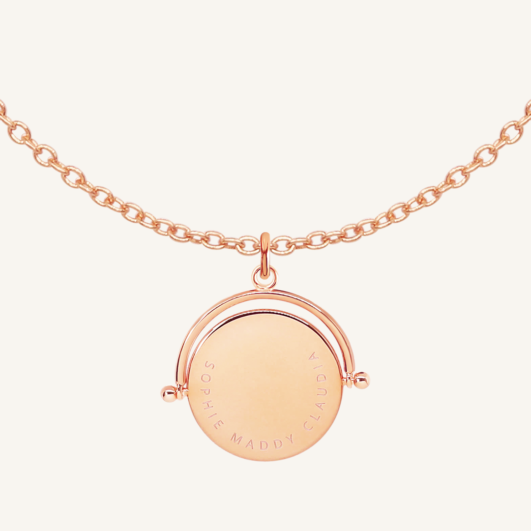 A rose-coloured, engraved pendant with, featuring a spinning mechanism, on chain