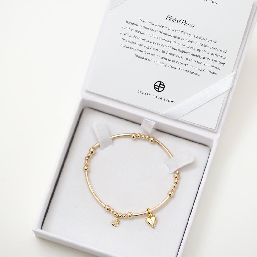 Gold bracelets with heart charm in white box