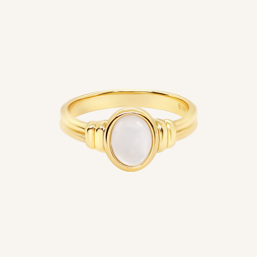 Gold ring with a Mother of Pearl stone on a white background