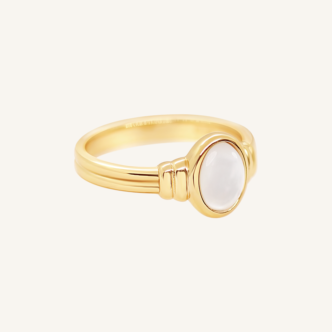 Gold ring with a Mother of Pearl stone on a white background