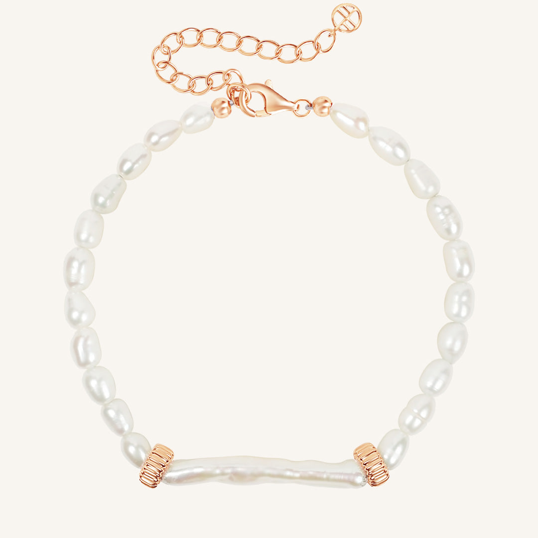 Pearl bracelet with rose gold accents on a white background