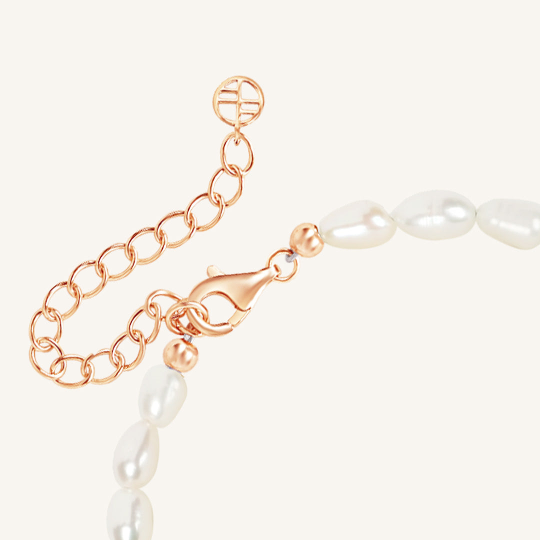 Pearl necklace with a rose gold clasp on a white background