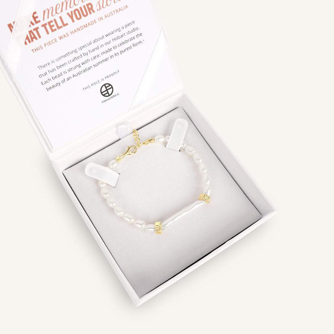 Bracelet with gold accents in a white box on a light background