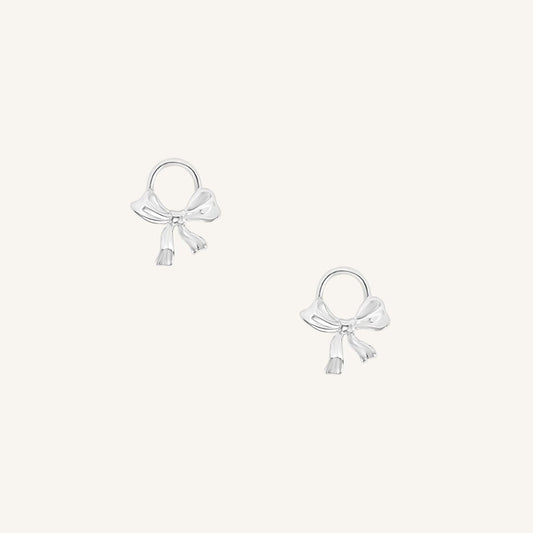 A set of two silver hoop charms with a bow design.