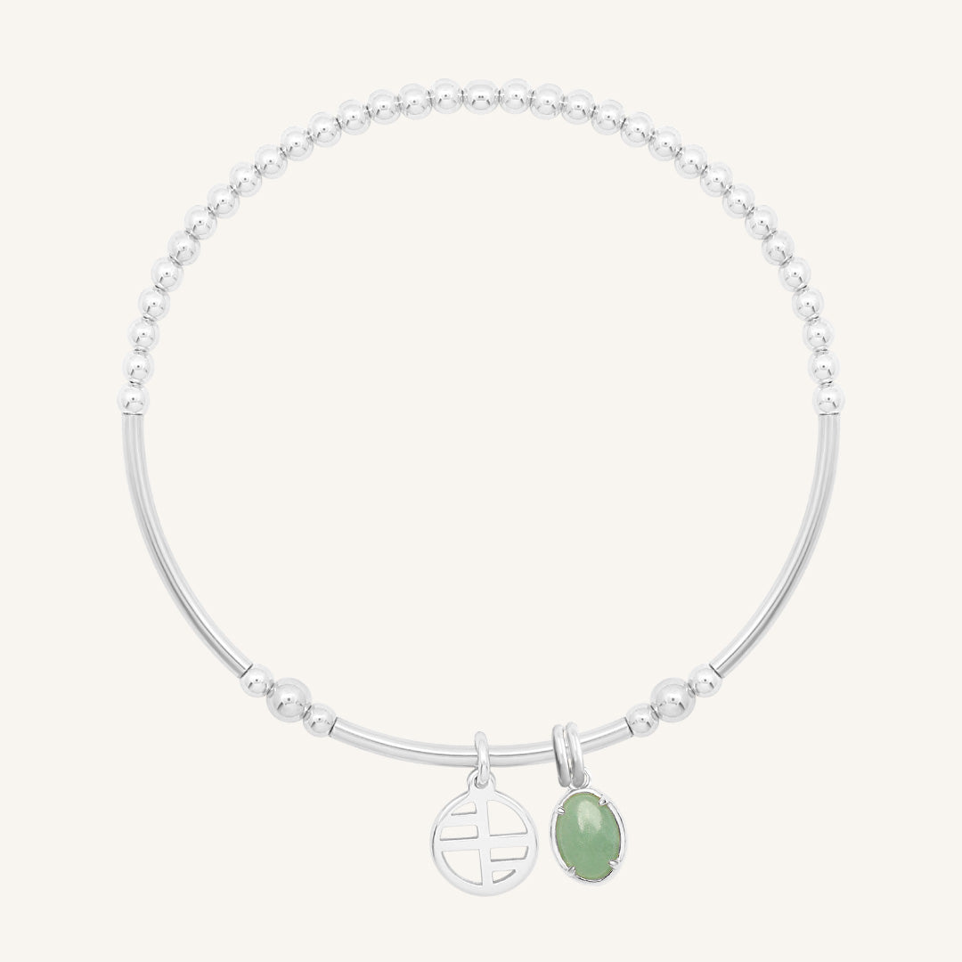 Silver bracelet with a green gemstone on a white background