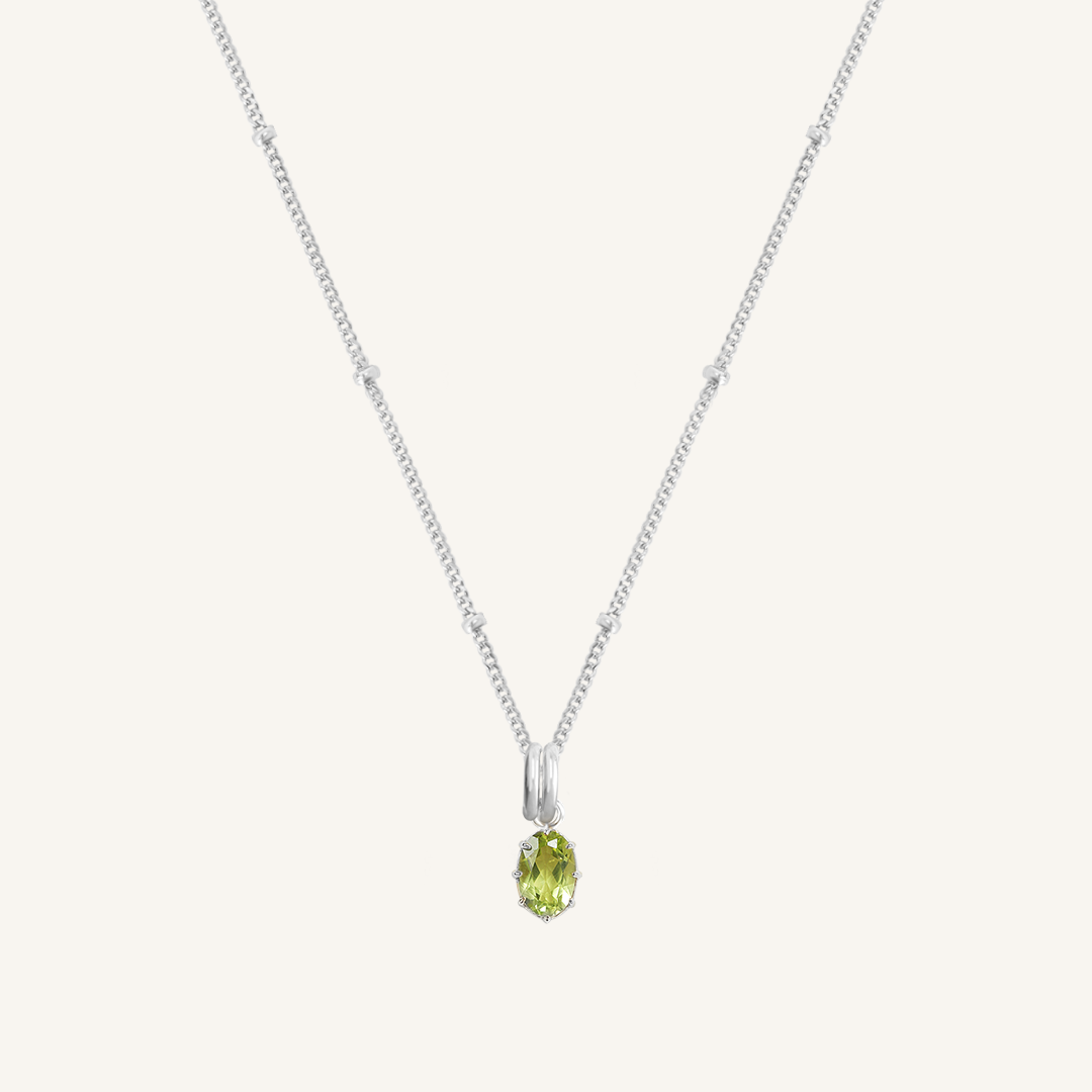 A green, oval-shaped charm pendant necklace with a silver metal chain.