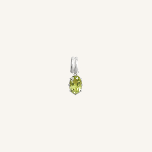 A silver charm with an olive green cubic zirconia, isolated on a white background.