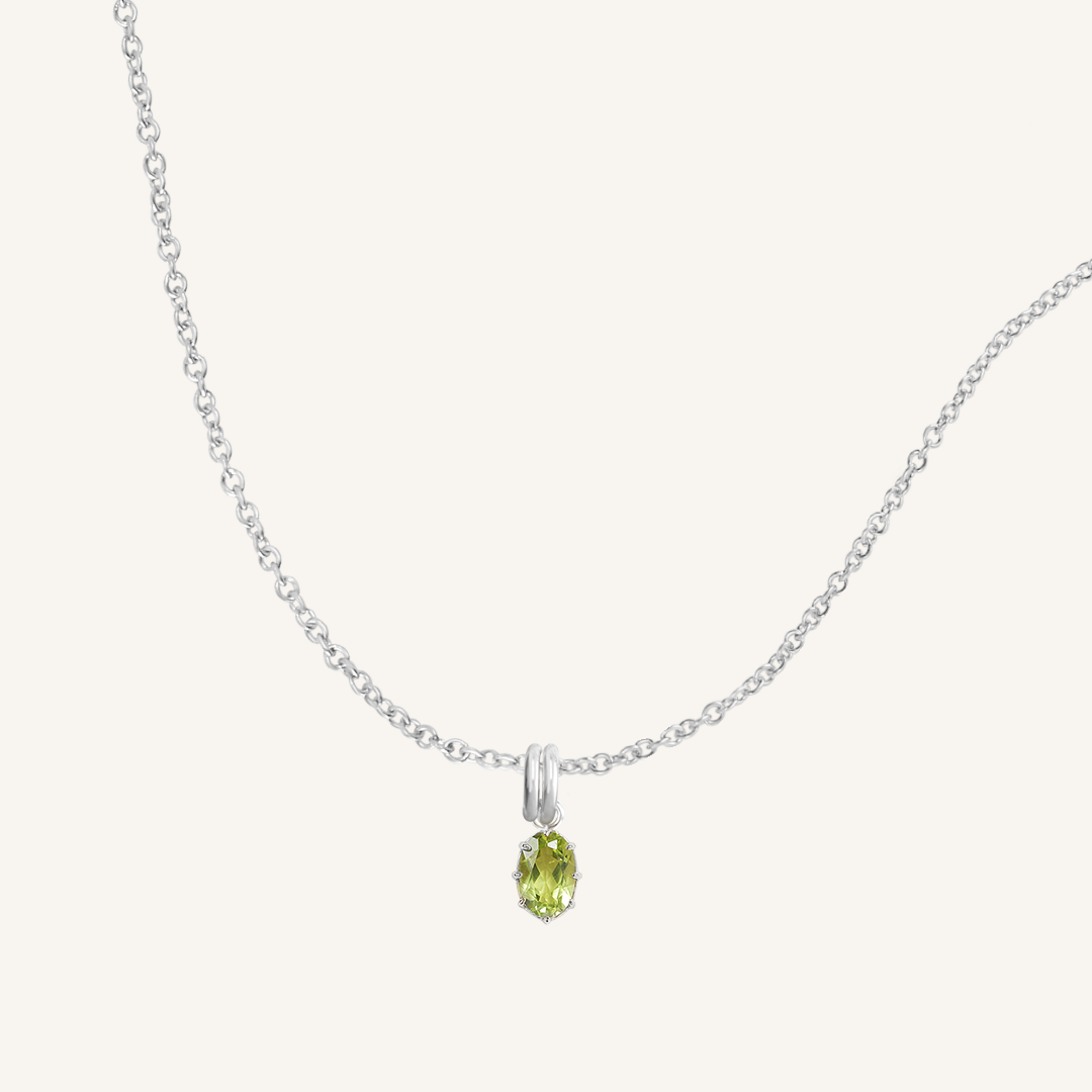 A green, oval-shaped charm pendant necklace with a silver metal chain.