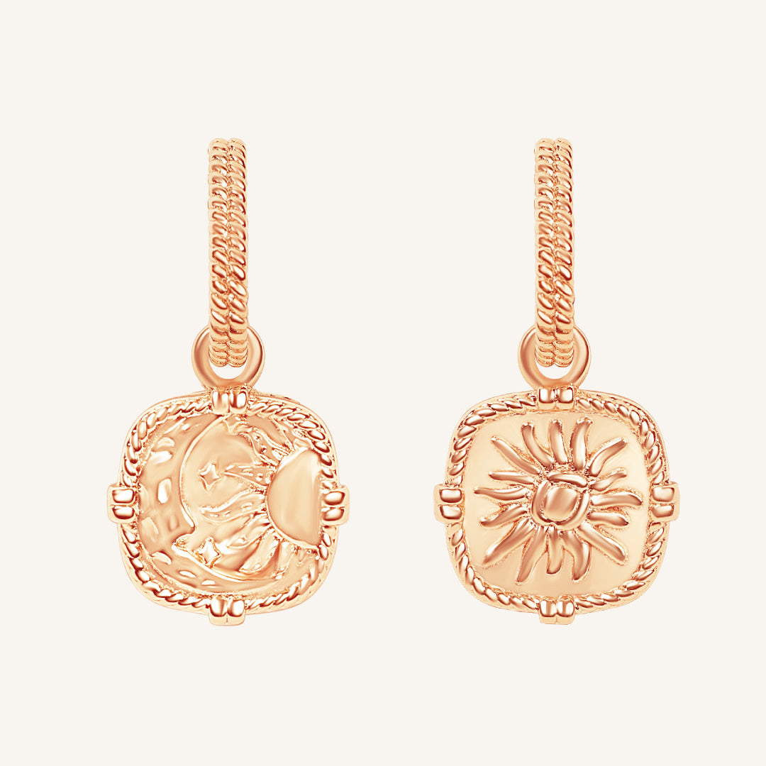Rose gold earrings with intricate designs on a white background