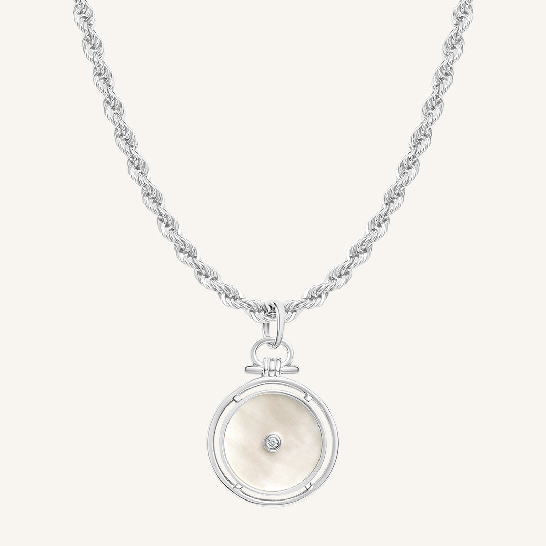 Silver necklace with a round pendant on a white background