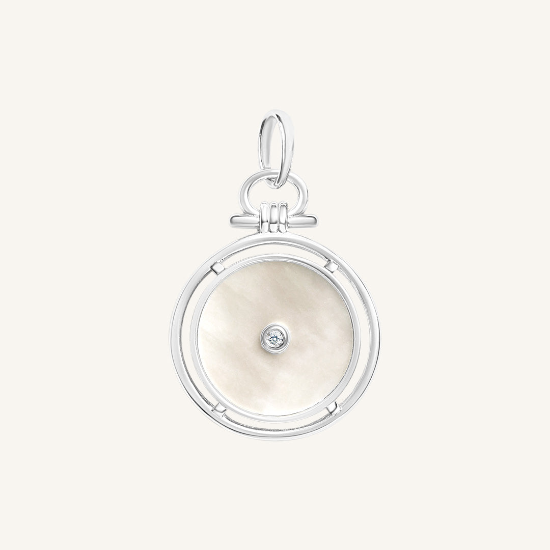 Silver pendant with a circular design and central gemstone on a white background