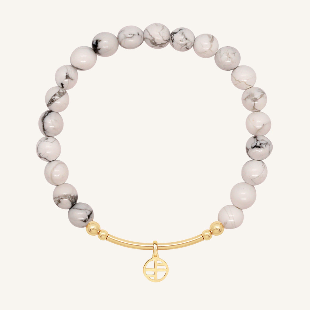 Bracelet with white beads and gold clasp on a white background