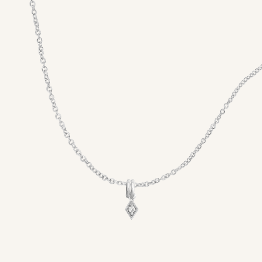 A delicate necklace featuring a small diamond charm pendant suspended from a silver-tone chain.