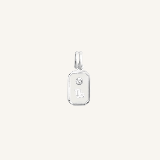 A silver rectangular shaped charm with the Capricorn zodiac symbol on it, designed with an iridescent finish.