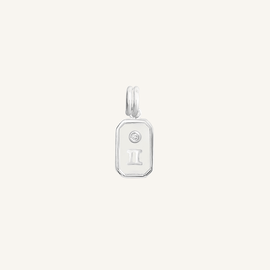 A silver rectangular shaped charm with the Gemini zodiac symbol on it, designed with an iridescent finish.