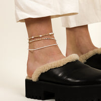 A coloured stretchy anklet with freshwater pearls and a small gold charm, displayed against a white background.