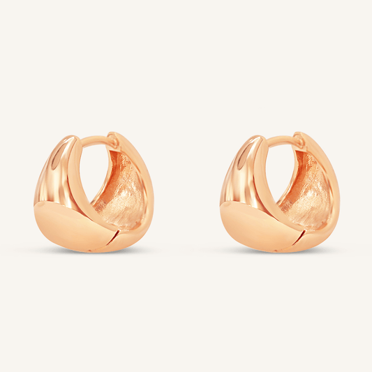 A pair of rose huggie hoop earrings on a white background.