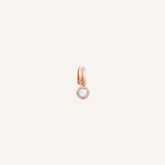 Round rose gold charm with bezel-set mother of pearl representing the June birthstone.