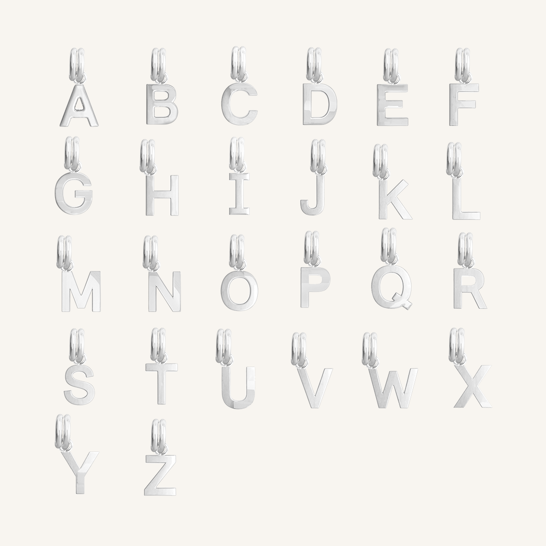 All silver letter charms on white background