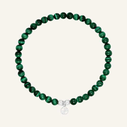 A beaded bracelet made of green malachite stones and metal beads with a silver-colored charm, displayed on a white background.