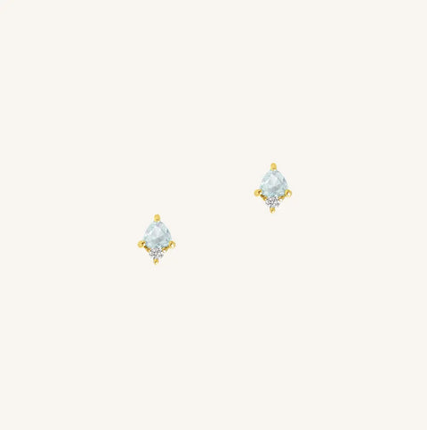 A gold pair of stud earrings featuring a blue cubic zirconia, representing March.