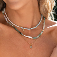 Silver pendant with a light blue gemstone on a white background