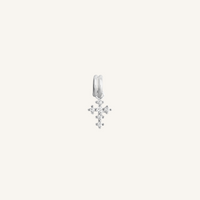 A petite silver cross charm with cubic zirconia on white background