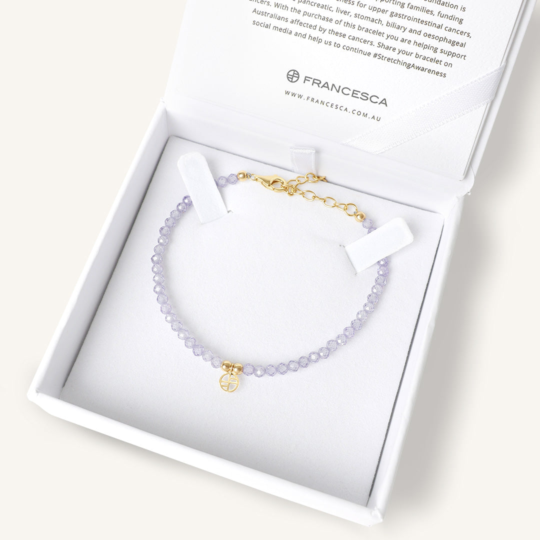 Bracelet with a gold charm in a Francesca box on a white background