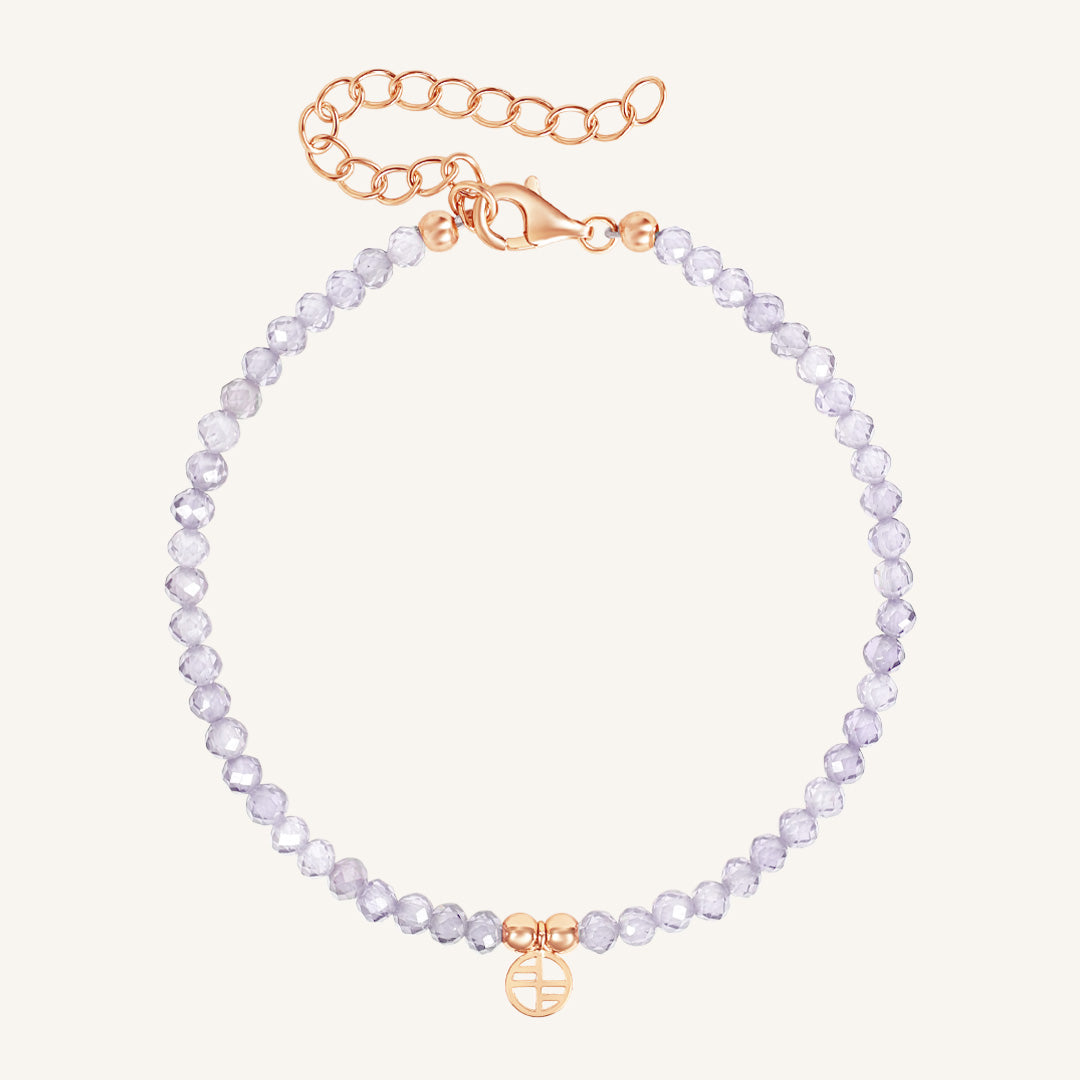 Bracelet with light purple beads and rose gold clasp on a white background