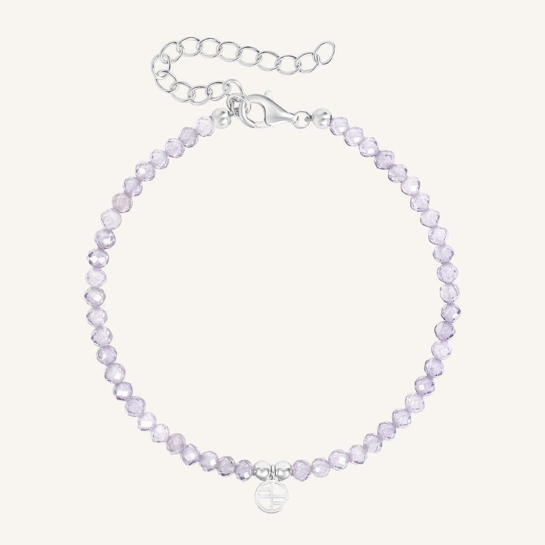 Silver bracelet with light purple beads on a white background