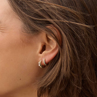 gold delicate huggies with a twist design on white background 