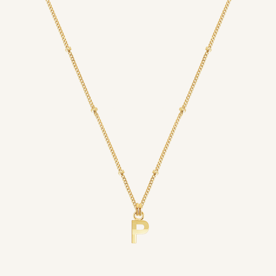 Gold necklace with a 'P' pendant on a white background