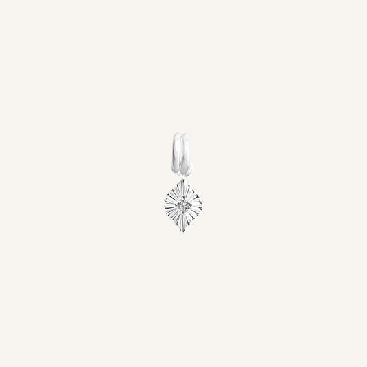 A silver birthstone charm with a purple cubic zirconia representing the month of February.