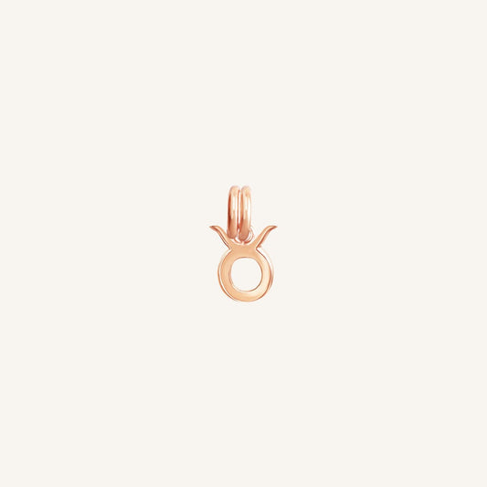 A rose gold-coloured Petite Zodiac Charm representing the Taurus sign.