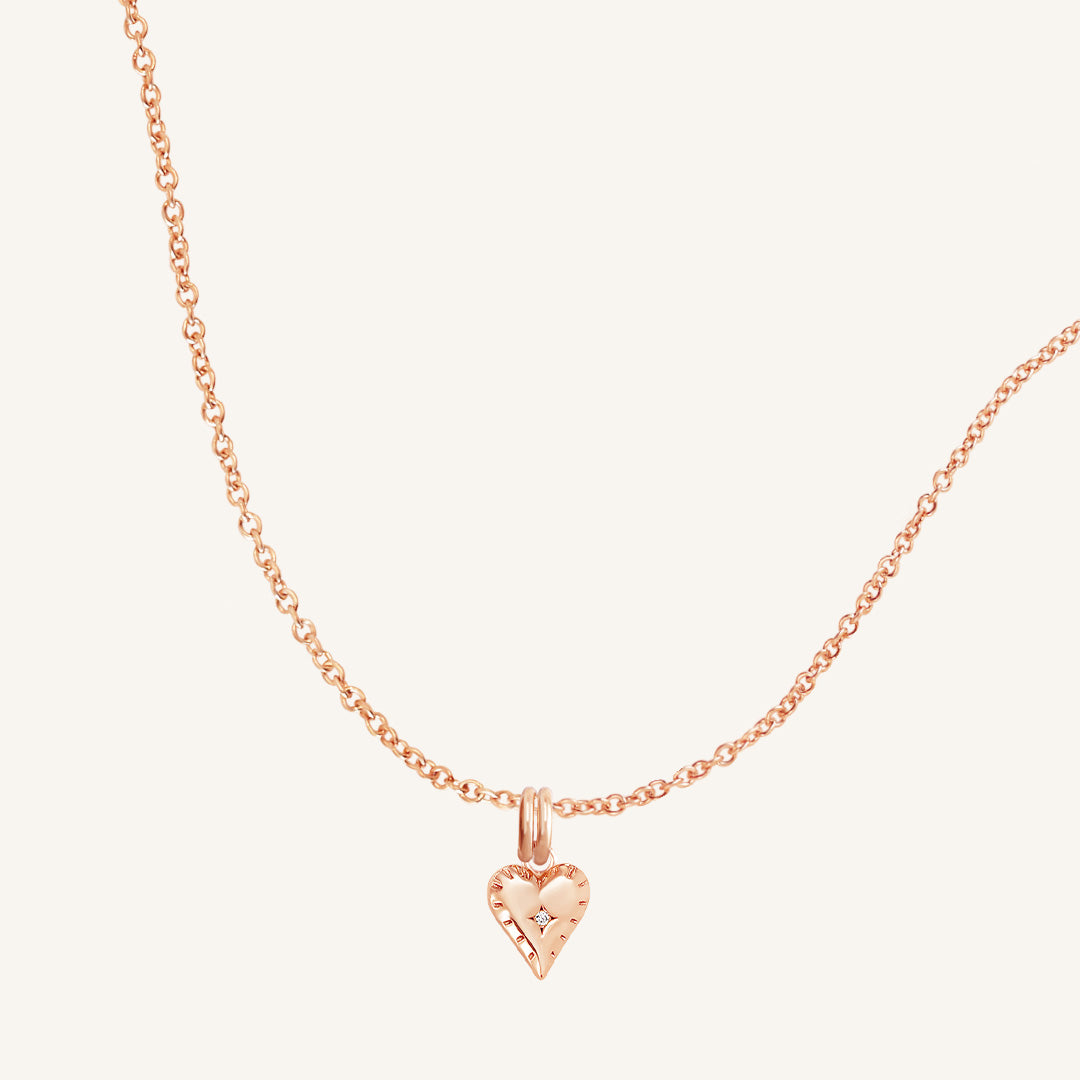 A gold-tone heart-shaped charm necklace with an adjustable chain.