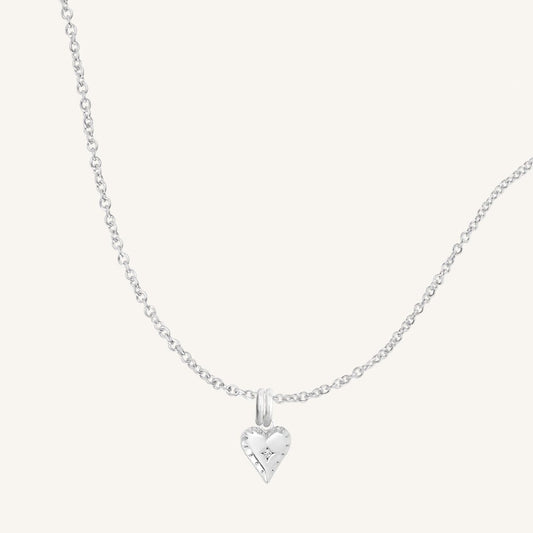 A silver-tone heart-shaped charm necklace with an adjustable chain.
