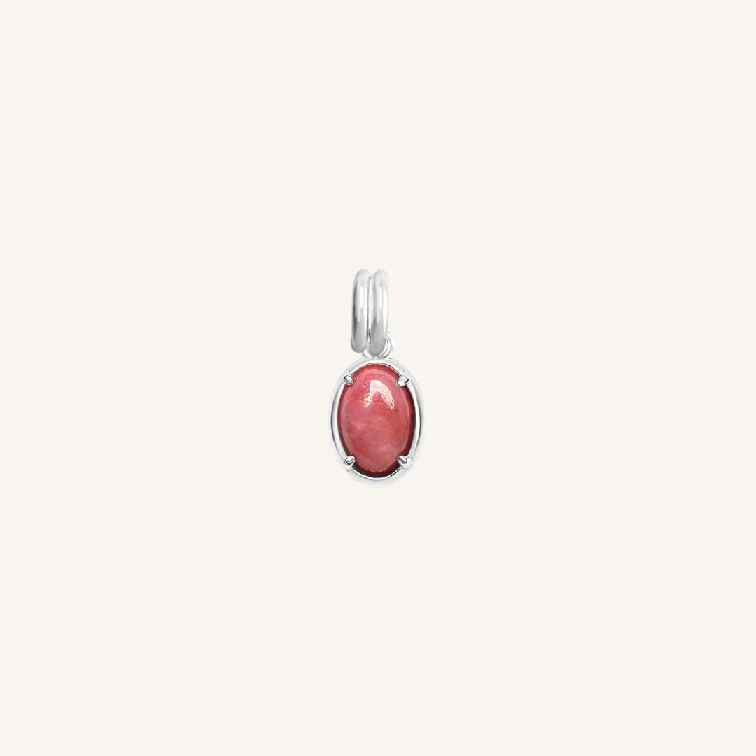 Silver charm with a pink gemstone on a white background