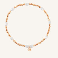 A coloured stretchy anklet with freshwater pearls and a small gold charm, displayed against a white background.