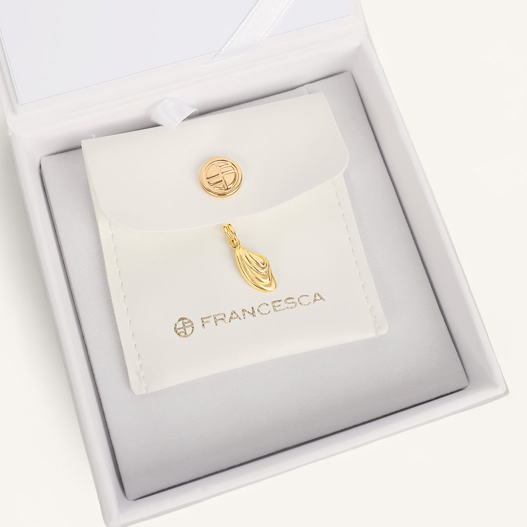 Gold earrings in a Francesca branded box on a white background