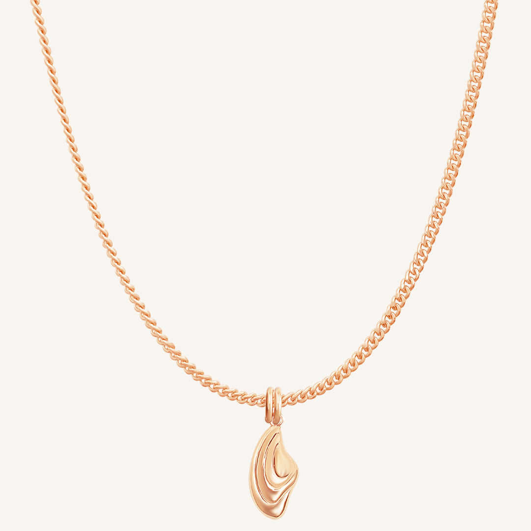 Rose gold necklace with a unique pendant on a light beige background