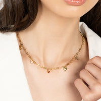 A gold chain necklace with paperclip links and multiple charms, showcasing where to solder charms and the option to choose the placement of the charms.