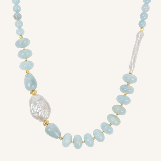 Necklace with light blue beads and a large pearl on a white background