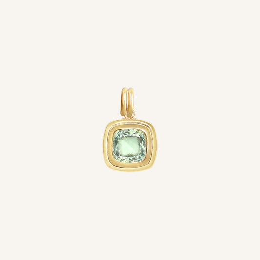 Gold pendant with a green gemstone on a white background